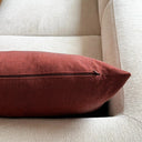 Närbild av tegelrött kuddfodral i mjukt tyg med linnekänsla