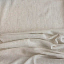 Ljust enfärgat gardintyg i linnelook med mjuk vävd struktur, tyget Lova uppvisat i tygveck.