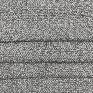 Närbild på möbeltyget Klint med grov boucléstruktur i melerad grå ton, visat med veck som framhäver den stadiga väven och den robusta kvaliteten.