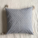 Grått Meja kuddfodral i bomull på säng med småmönstrat tyg och tofsar