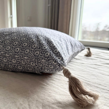 Närbild av Meja kuddfodral med dekorativ tofs i hörnet