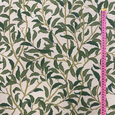 Närbild av tyget Olivia i bomull och linne, visar mönstrets skala och vävens struktur med måttband som referens.