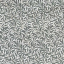 Mönstrat tyg Ramas i dov grön nyans, med tät väv och dekorativt bladmotiv.