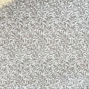 Mönstrat tyg Ramas i ljusbeige ton, med tät väv och dekorativt bladmotiv.