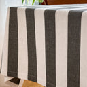 Randig bordsduk i återvunnen bomull i skandinavisk stil över ett träbord.