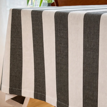 Randig bordsduk i återvunnen bomull i skandinavisk stil över ett träbord.