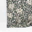 Mönstrat bomullstyg Siv med blommor och slingrande blad i gröna och beige toner, fotograferat med måttband för att visa mönsterskala