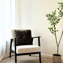 Svart kuddfodral 45x45 i fårskinnsimitation på fåtölj i vardagsrum