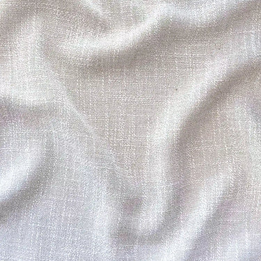 Närbild på Sophia gardintyg i 100 % polyester med mjuk struktur, vackert fall och ljusbeige ton.