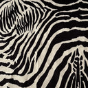Närbild på möbeltyget Wilda med svartvitt zebramönster och mjuk, sammetsliknande yta som framhäver tygets taktila struktur och exklusiva uttryck.