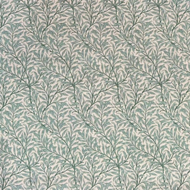 Mönstrat tyg Ramas i dämpad salviagrön, med tät väv och dekorativt bladmotiv.