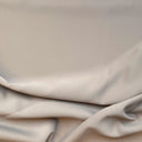 Slätt mörkläggningstyg i beige färg med mjuk yta och naturliga veck