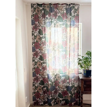 Blommig linnégardin Cecilia upphängd i fönster med naturligt ljus och växt i rummet