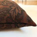 Närbild av jacquardliknande tyg i brun färg på kuddfodral Astrid