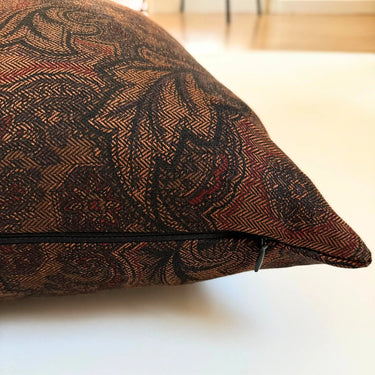 Närbild av jacquardliknande tyg i brun färg på kuddfodral Astrid