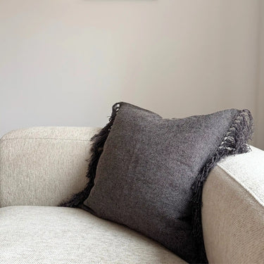 Kuddfodral Freja i strukturerat tyg med fransar, placerad på ljus soffa