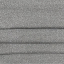 Närbild på möbeltyget Klint med grov boucléstruktur i melerad grå ton, visat med veck som framhäver den stadiga väven och den robusta kvaliteten.