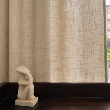 Beige gardintyg i linnelook med struktur, släpper igenom ljus och skapar en varm känsla