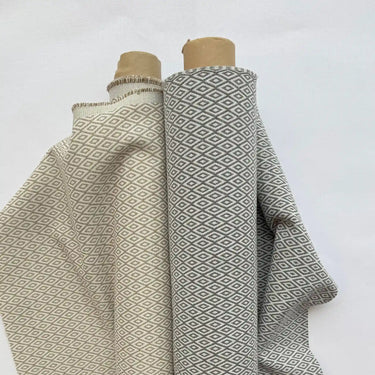 Grå och beige varianter av möbeltyget Saga. Tätt rutmönster i slitstark bomulls- och polyestermix, perfekt för dagligt bruk.