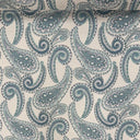 Möbeltyget Alvar med klassiskt paisleymönster i blågröna toner på ljus botten, med måttband som visar mönstrets storlek.