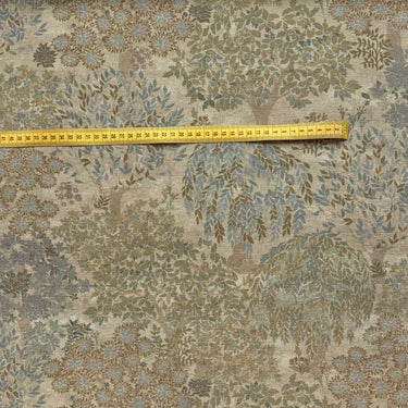 Detaljbild av Aran klassiskt mönstrat möbeltyg med måttband som visar mönstrets storlek.