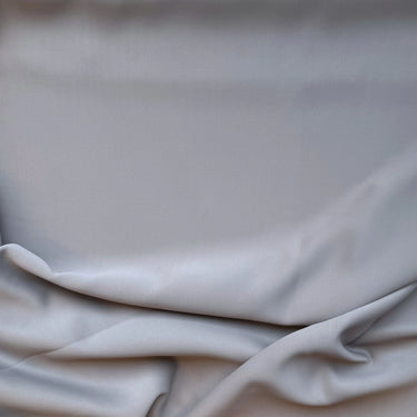 Slätt mörkläggningstyg i grå färg med mjuk yta och naturliga veck