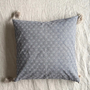 Grått Meja kuddfodral i bomull på säng med småmönstrat tyg och tofsar