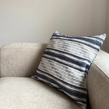 Kuddfodral i 100% bomull med vävd struktur och mörkblå ränder på soffa