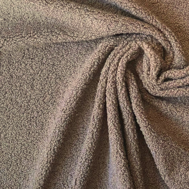 Brunt möbeltyg Mimmi draperat i spiral för att visa fall och struktur. Mjukt men hållbart tyg i 100 % polyester.