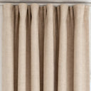 Beige gardin med jämna veck upptill, ger ett stilrent och mjukt fall