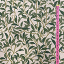 Närbild av tyget Olivia i bomull och linne, visar mönstrets skala och vävens struktur med måttband som referens.