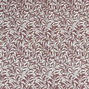 Mönstrat tyg Ramas i tegelröd ton, med tät väv och dekorativt bladmotiv.