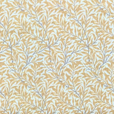 Mönstrat tyg Ramas i senapsgul nyans, med tät väv och dekorativt bladmotiv.