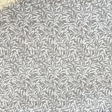 Mönstrat tyg Ramas i ljusbeige ton, med tät väv och dekorativt bladmotiv.