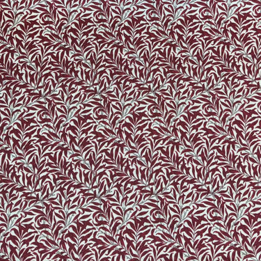 Mönstrat tyg Ramas i vinröd nyans, med tät väv och dekorativt bladmotiv.
