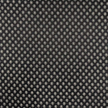 Romeo möbeltyg i svart med små tätt placerade motiv som skapar en subtil prickig struktur. Dubbelvävt tyg för möbelklädsel och vardagligt bruk.