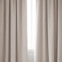 Mörkläggningsgardin i beige tyg som blockerar ljus framför fönster