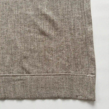 Detaljbild av beige gardin med sydd nederkant och vikt fåll för ett snyggt fall