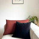 Tegelrött kuddfodral i mjukt tyg med linnekänsla tillsammans med svart kudde