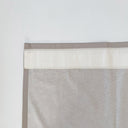 Närbild av veckband som är fastsytt på gardinens baksida. Visar hur bandet placeras upptill för att skapa ett stilrent och skräddarsytt fall.