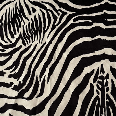 Närbild på möbeltyget Wilda med svartvitt zebramönster och mjuk, sammetsliknande yta som framhäver tygets taktila struktur och exklusiva uttryck.