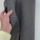 Hand som visar struktur och tjocklek på ljusbeständigt utomhustyg för dynor och utemöbler.