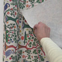 Hand som rör möbeltyget Alice och visar tygets egenskaper och naturliga struktur i rörelse.