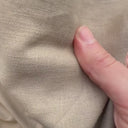 Hand som visar strukturen i gardintyget Ludwig – mjukt linne/bomull som faller naturligt