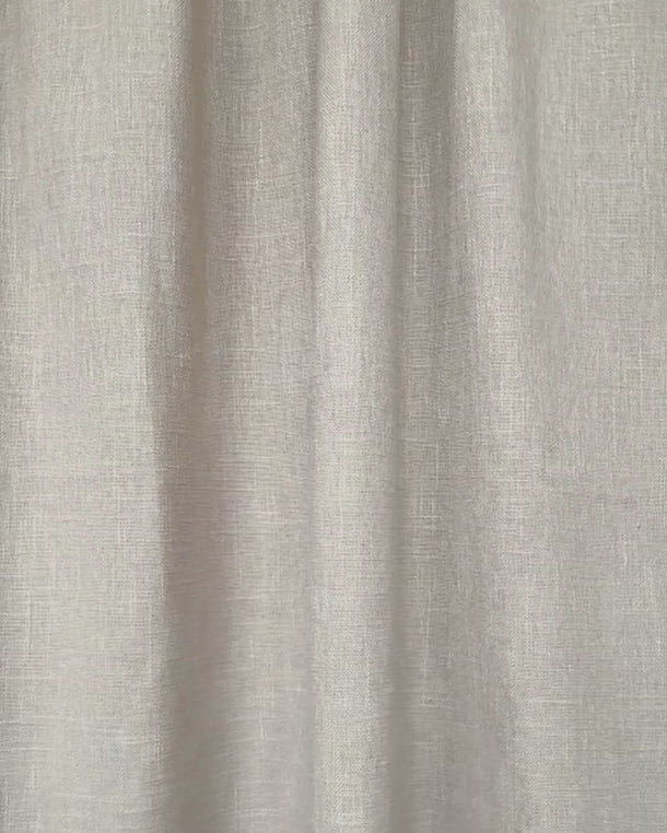 Beige gardintyg “Göran” i slow motion som rör sig mjukt i ljuset och visar tygstruktur, fall och naturlig textur.