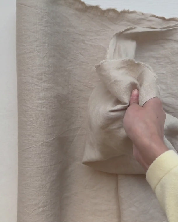 Video där en hand känner på tyget Sabina i 100 % tvättat linne och visar tygets struktur och naturliga fall.