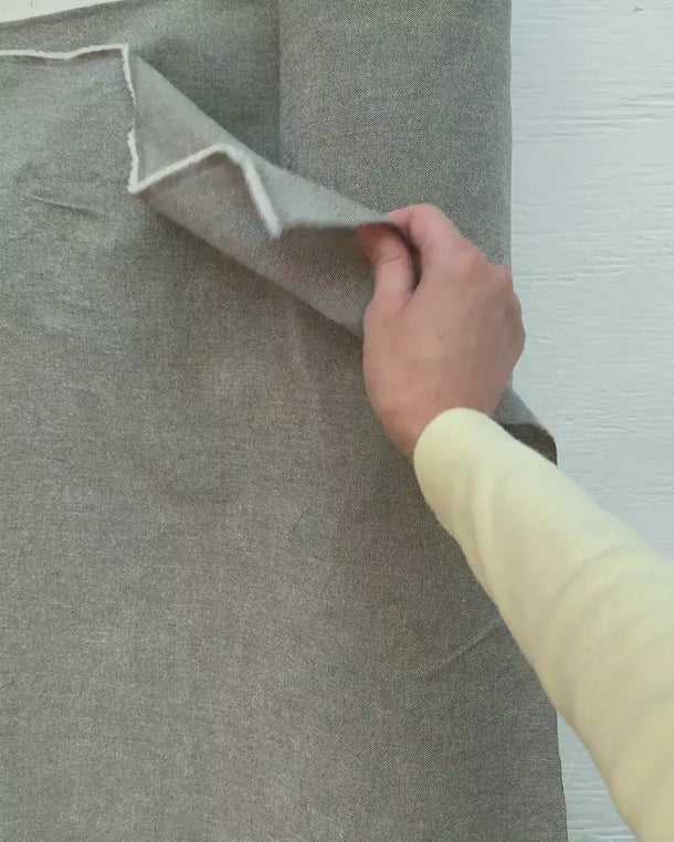 Video där en hand känner på tyget Viktoria i återvunnen bomull och visar tygets struktur och naturliga fall.